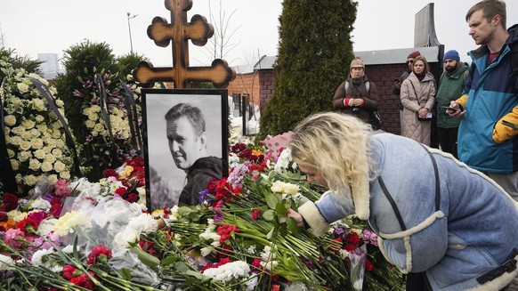 02.03.2024, Russland, Moskau: Eine Frau legt einen Tag nach der Beerdigung von Alexej Nawalny auf dem Borisowskoje-Friedhof Blumen am Grab ab. Nawalny, der der schärfste Gegner von Präsident Wladimir  ...