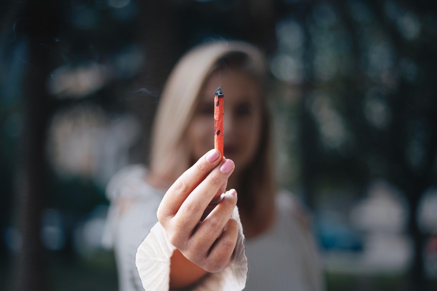 Blonde girl holding red joint
