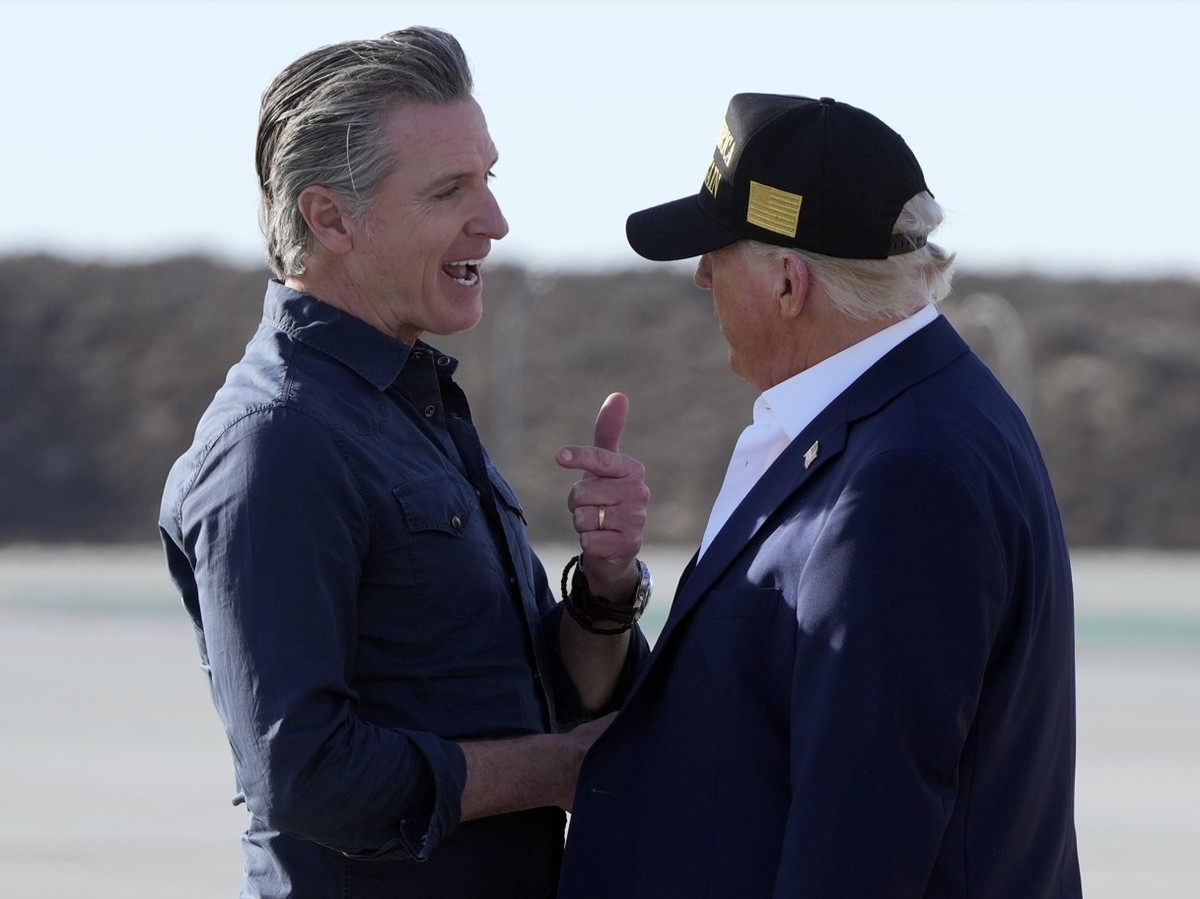 President Donald Trump talks with California Gov. Gavin Newsom as first lady Melania Trump listens after arriving on Air Force One at Los Angeles International Airport in Los Angeles, Friday, Jan. 24, ...