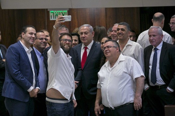 Knesset-Abgeordnete machen ein Selfie Israels Premier-Minister Minister Benjamin Netanyahu (Mitte) nach der Abstimmung über das umstrittene Gesetz.