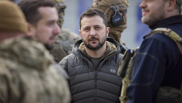14.11.2022, Ukraine, Cherson: Wolodymyr Selenskyj (M), Präsident der Ukraine, ist umgeben von Sicherheitskräften, während er einen Rundgang durch die zurückeroberte Stadt Cherson macht. Foto: Ukraine ...