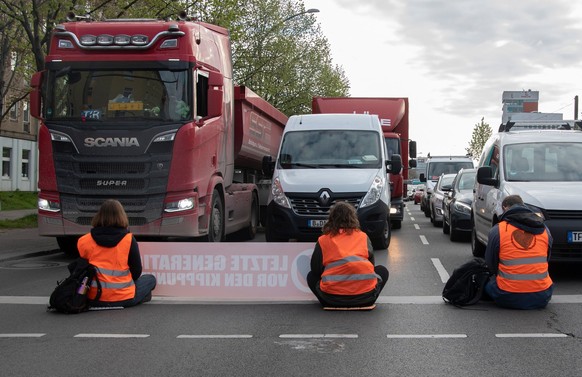 27.04.2023, Berlin: Aktivisten der Gruppierung Letzte Generation blockieren eine Kreuzung an der Landsberger Allee. Foto: Paul Zinken/dpa +++ dpa-Bildfunk +++
