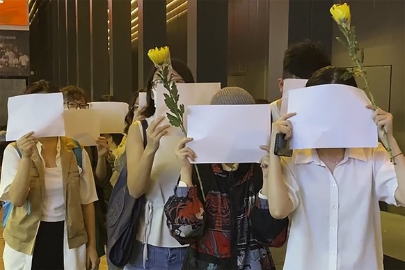 Protesters hold up blank white papers during a commemoration for victims of a recent Urumqi deadly fire in Central in Hong Kong, Monday, Nov. 28, 2022. Students in Hong Kong chanted “oppose dictatorsh ...