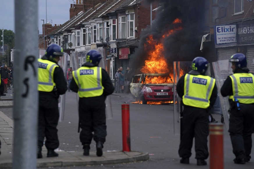 A car burns during an anti-immigration protest in Middlesbrough, England, Sunday Aug. 4, 2024. (Owen Humphreys/PA via AP)