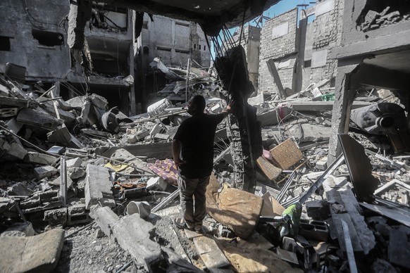 12.10.2023, Palästinensische Gebiete, Gaza-Stadt: Ein Palästinenser steht inmitten der Trümmer von Gebäuden, die bei israelischen Luftangriffen im Flüchtlingslager Al Shati zerstört wurden. Foto: Moha ...