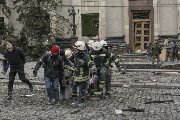 Rettungskräfte bergen in Charkiw nach Beschuss die Leiche eines Opfers.
