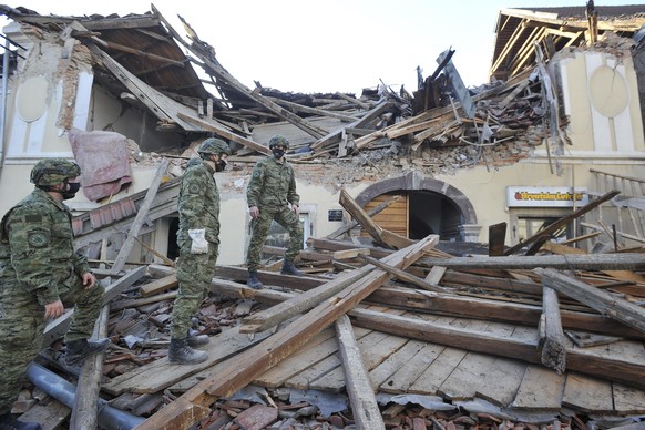 29.12.2020, Kroatien, Petrinja: Soldaten inspizieren die Trümmer eines vom Erdbeben beschädigten Gebäudes. Ein Erdbeben der Stärke 6,4 hat nach Angaben von Seismologen erneut die kroatische Zentralreg ...