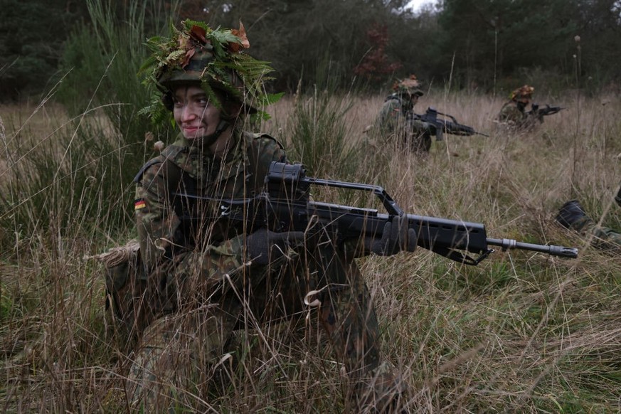 PRENZLAU, GERMANY - NOVEMBER 29: A female army (Heer) recruit of the Bundeswehr, Germany&#039;s armed forces, is armed with a Heckler &amp; Koch G36 assault rifle as she participates in basic training ...