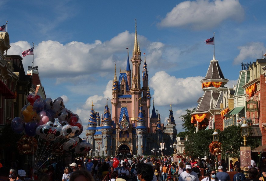 Cinderella Castle is decorated with gold ribbons, blue banners, a 50th-anniversary sign and EARidescent embellishment at Magic Kingdom Park during &quot;The World&#039;s Most Magical Celebration&quot; ...