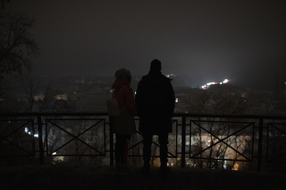 dpatopbilder - 23.11.2022, Ukraine, Kiew: Menschen stehen w�hrend eines Stromausfalls nach einem russischen Raketenangriff an einem Aussichtspunkt. Foto: Andrew Kravchenko/AP/dpa +++ dpa-Bildfunk +++
