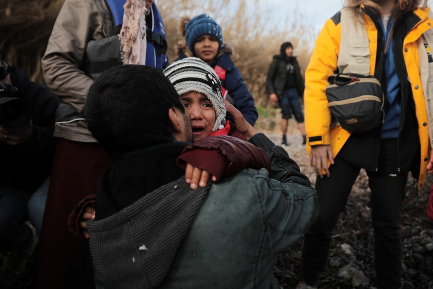 A child reacts as migrants from Afghanistan arrive on a dinghy on a beach near the village of Skala Sikamias on the island of Lesbos, Greece, February 28, 2020. REUTERS/Costas Baltas