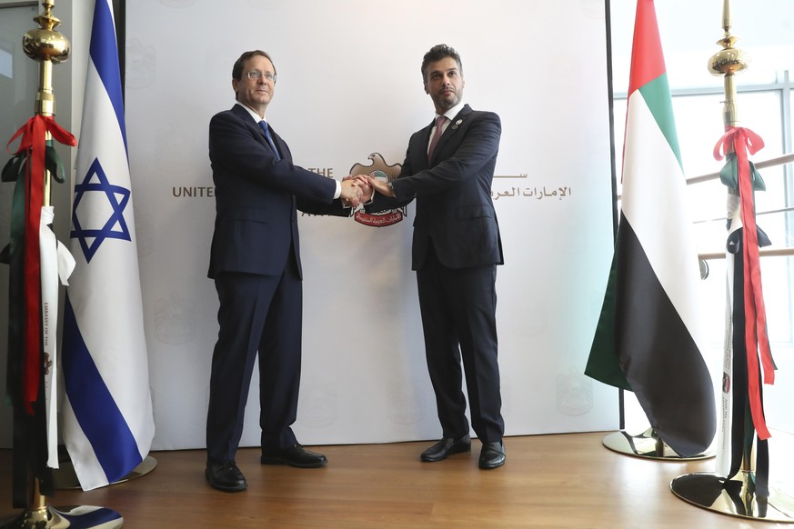 Israel&#039;s President Isaac Herzog, left, shakes hands with United Arab Emirates ambassador to Israel Mohamed Al Khaja during the opening ceremony for the new UAE Embassy in Tel Aviv, Israel, Wednes ...